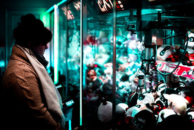 Side view of people looking at illuminated store