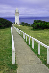 Lighthouse by sea against sky