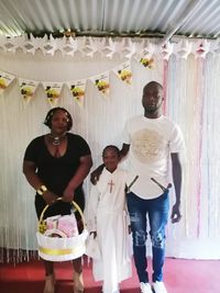 Portrait of a smiling young man standing against wall