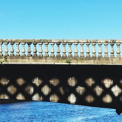 Bridge over sea against clear blue sky