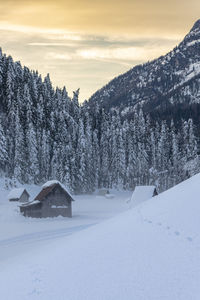 Scenic view of snow covered landscape and houses against sky