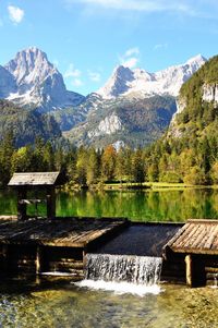 Gazebo by lake against mountains