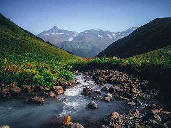 Scenic view of river amidst mountains against sky