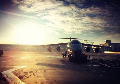 Airplane on airport runway against sky