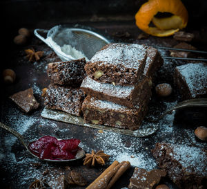 Brownie squares sprinkled with sugar on a black table