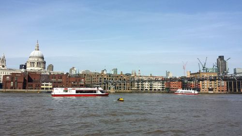 Boats in river with buildings in background