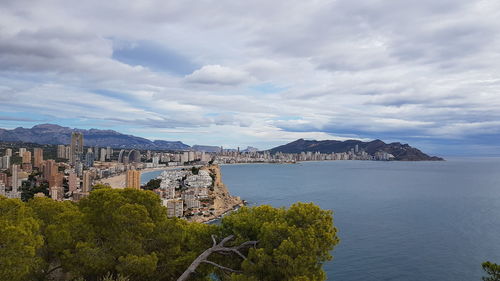 Panoramic view of city by sea against sky