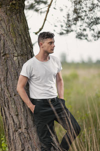 Young man standing on tree trunk