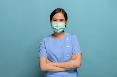 Portrait of girl standing against blue background