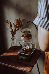 Midsection of woman with red wine in glass on table