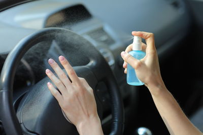 Cropped hand of man washing car