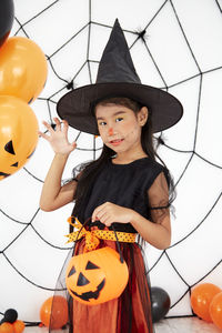 Low angle view of girl standing by pumpkin