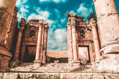 Low angle view of old temple against cloudy sky