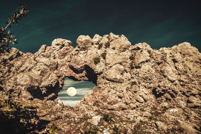 Low angle view of moon seen through rock formation