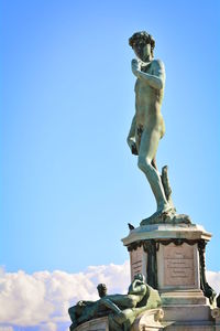 Low angle view of statue against blue sky