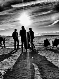 Silhouette people walking on beach