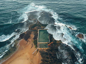 High angle view of waves breaking on rocks