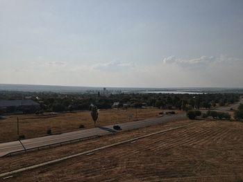 Scenic view of road by sea against sky