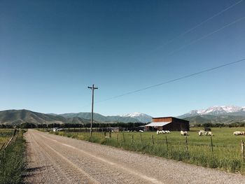 Road by mountains against clear sky