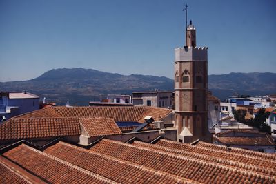 View of buildings and roofs in town against sky