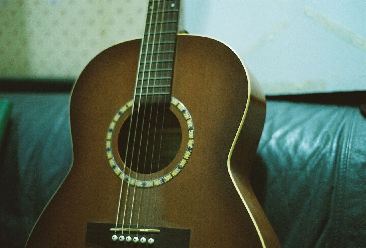 CLOSE-UP OF GUITAR IN ROOM