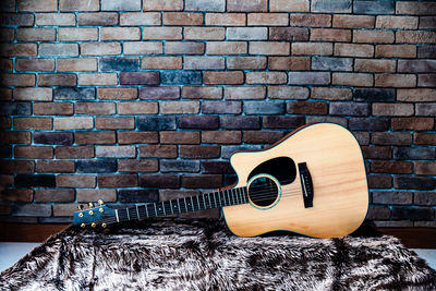 Close-up of guitar against wall at home