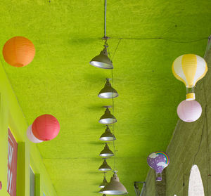 Low angle view of illuminated lanterns hanging against wall