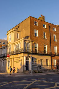 Street by building against clear blue sky