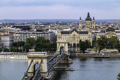 Bridge over river against buildings in city