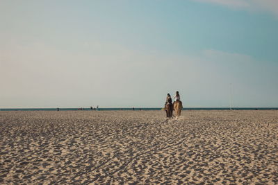 People on beach against sky