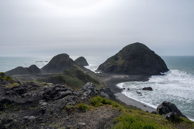Rock formations by sea against sky