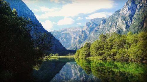 River with trees and mountains against cloudy sky