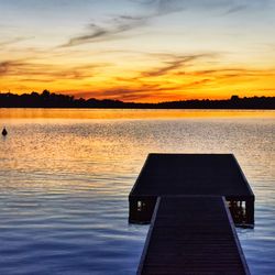Scenic view of lake against orange sky