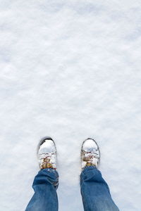 Low section of man standing on snow