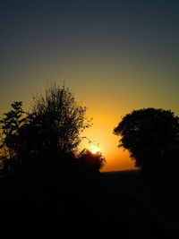 Silhouette trees against sky during sunset