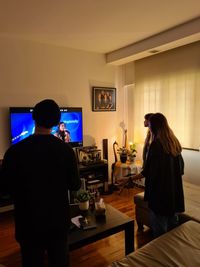 Rear view of man and woman standing at home