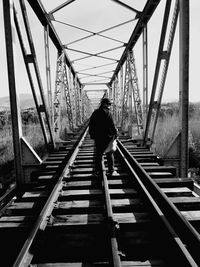 Rear view of man standing on railway bridge