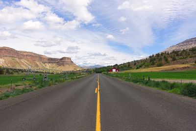 Empty road along countryside landscape