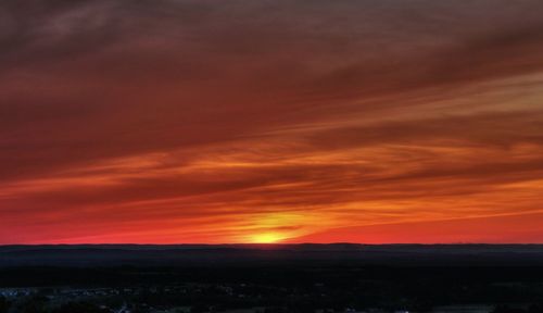 Scenic view of landscape against orange sky