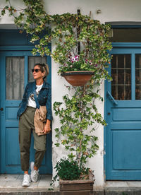 Full length of woman standing outside house against building