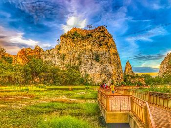 View of rock formations on landscape against cloudy sky