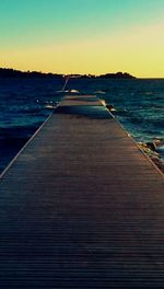 Pier on sea at sunset