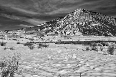 Scenic view of lake by snow mountains against sky