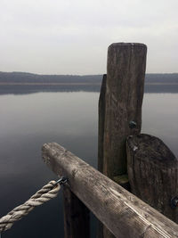 Wooden pier on lake against sky