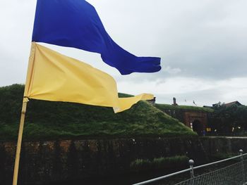 Low angle view of flag against sky in city