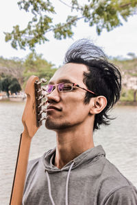 Portrait of young man wearing sunglasses against sky