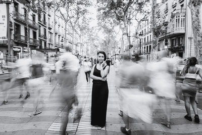 Portrait of woman standing on street in city