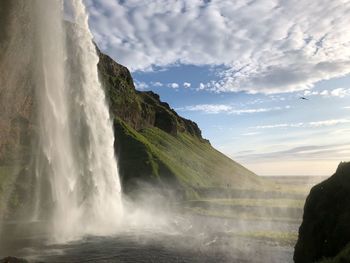 Scenic view of waterfall against sky