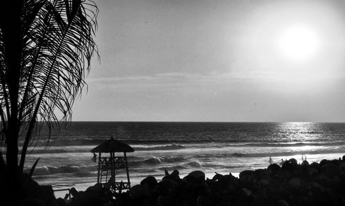 Silhouette people on beach against clear sky