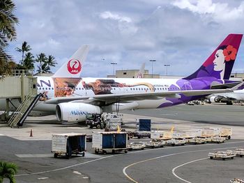 Airplane on airport runway against sky